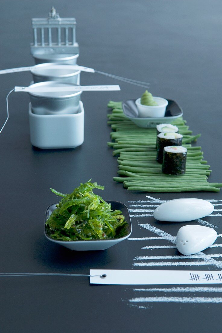 Table set with sushi, seaweed salad and beans