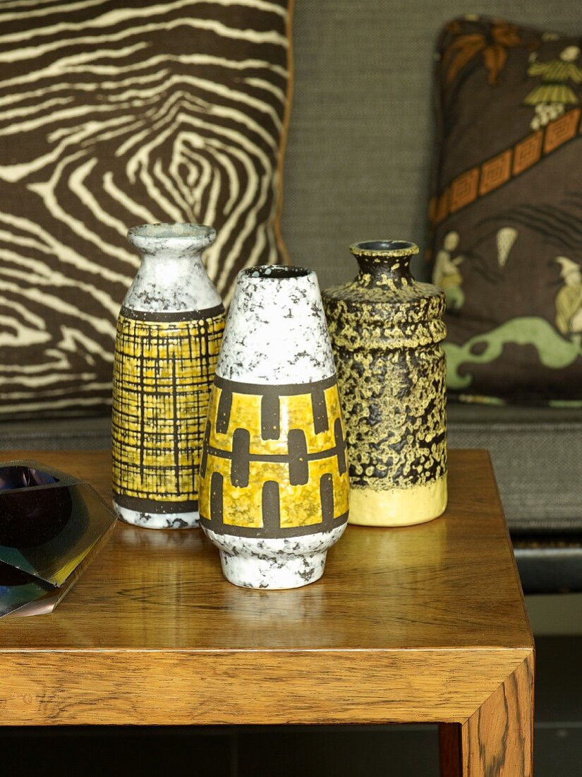 Collection of fifties-style vases painted back and yellow on oak coffee table