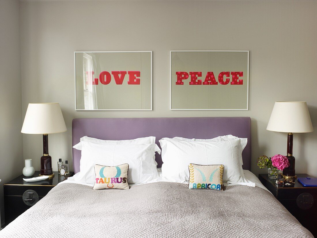 Bilder mit Schriftzügen LOVE und PEACE über Doppelbett mit violettem Kopfteil und kleinen Zierkissen