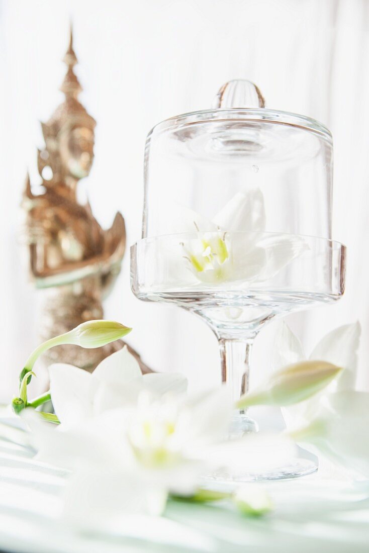 weiße Lilien und Statue aus Asien als Tischdeko