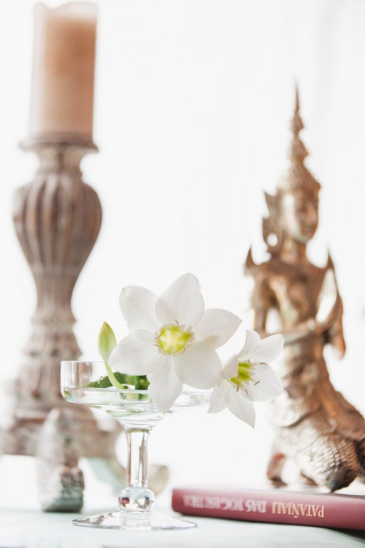 weiße Lilien, Kerzenleuchter und Statue aus Asien als Tischdeko
