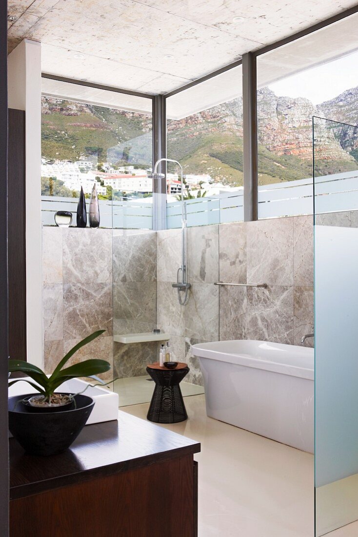 Puristisches elegantes Bad mit umlaufendem Fensterband und Bergblick