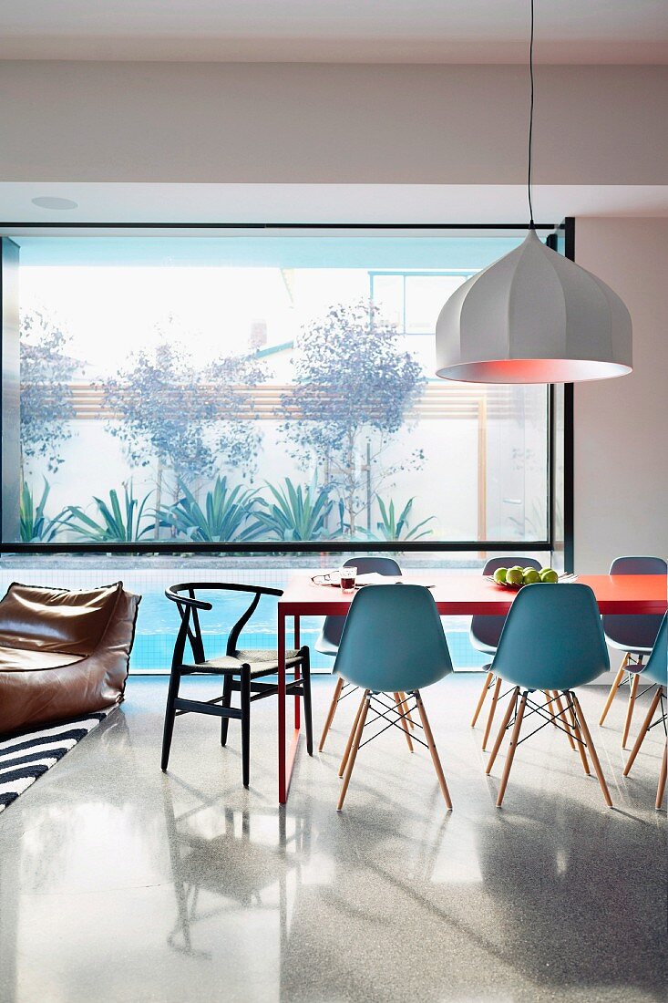Offener Wohn-Essbereich mit Panoramafesnter und Designer Klassikermöbel eingerichtet