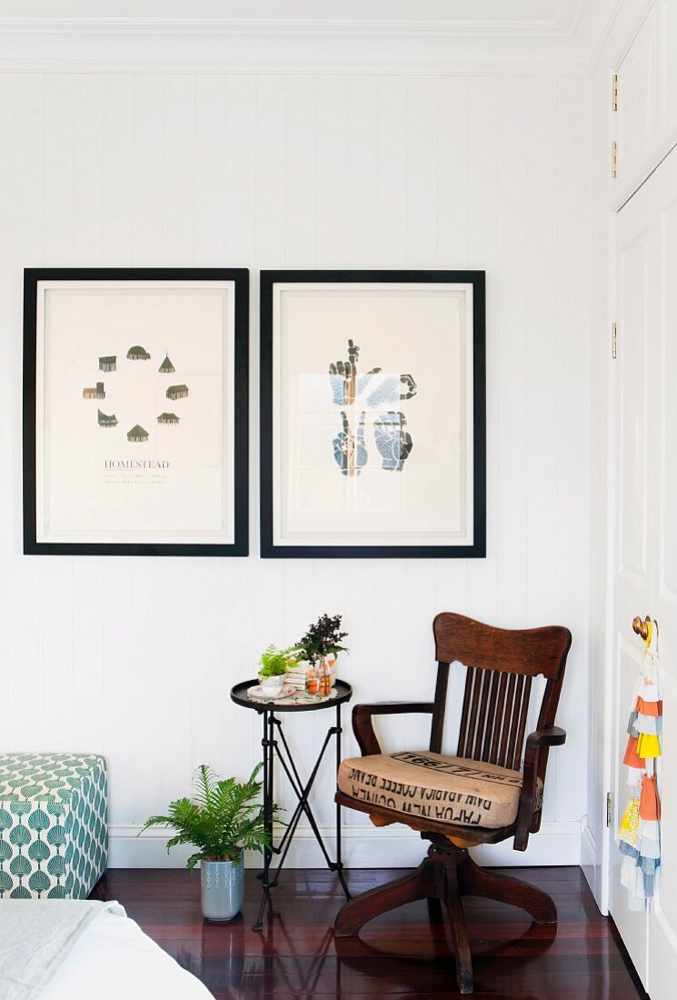 Zwei gerahmte Druck-Bilder und antiker Armlehnstuhl, Beistelltisch mit Zimmerpflanzen neben weißem Wandschrank
