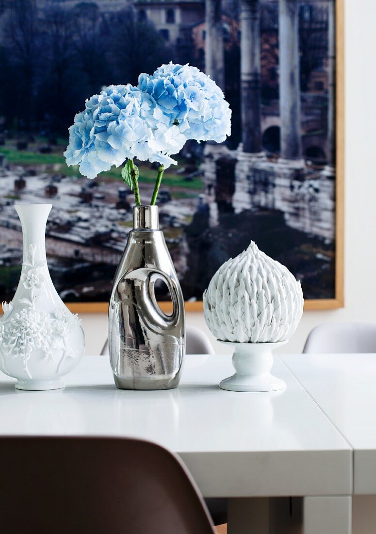 Vasensammlung aus Flohmarktfunden mit pastellblauen Hortensien