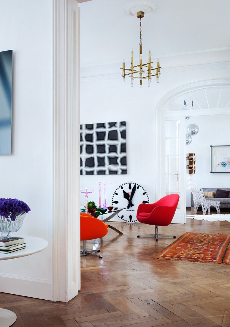 Durchblick durch drei ineinander übergehende Zimmer einer Wiener Altbauwohnung mit moderner Kunst, Retro und Designer Möbeln