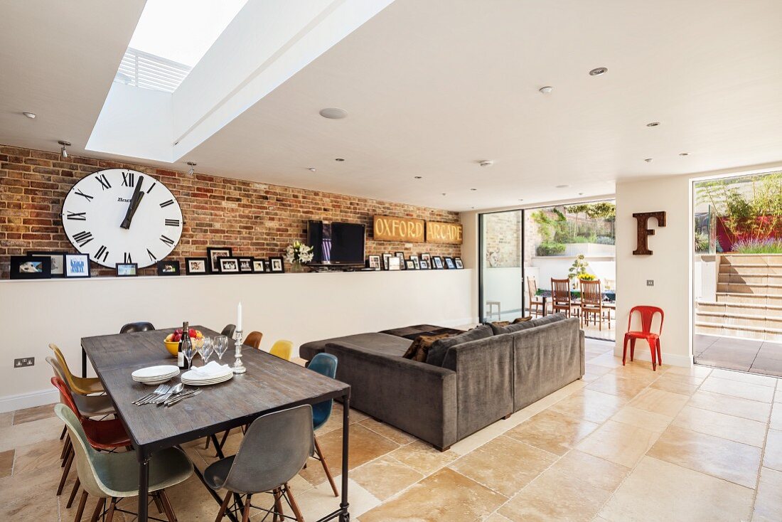 Open-plan interior in modern extension with exposed brickwork, designer furniture and access to terrace