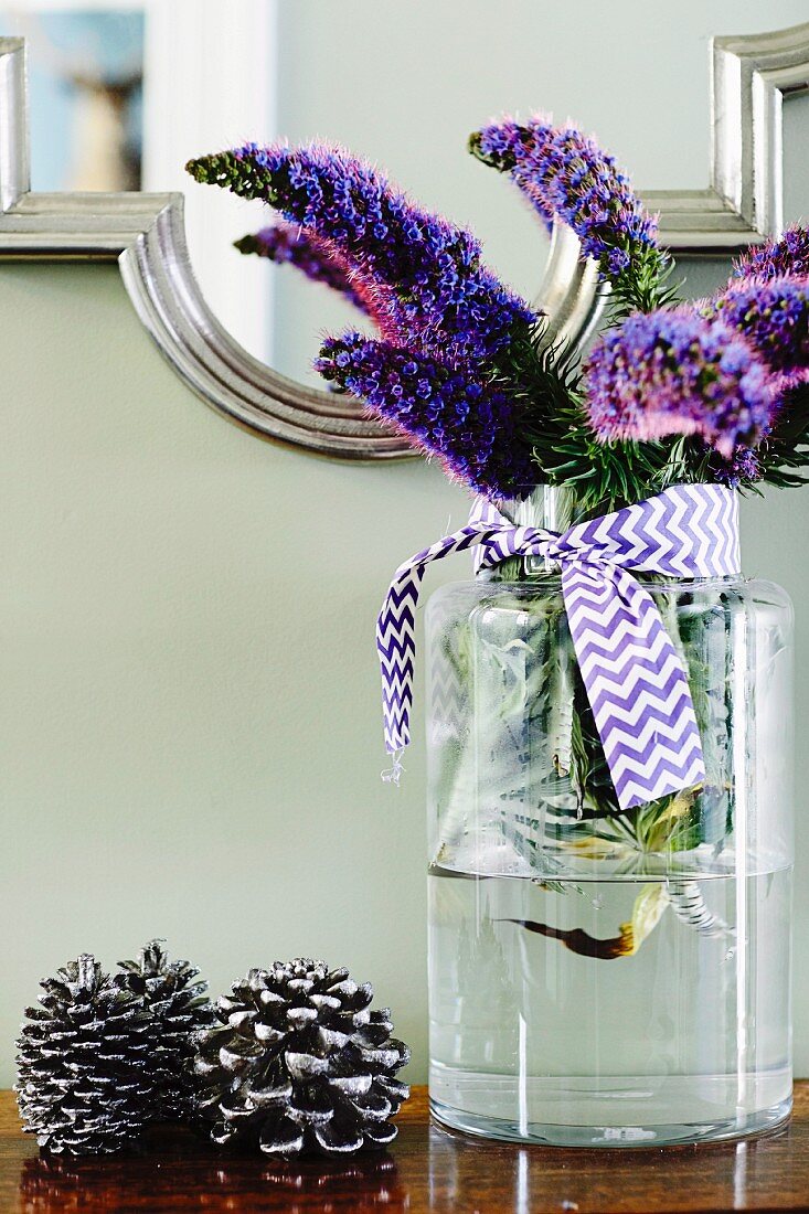 Glass vase of echium flowers tied with purple and white satin ribbon