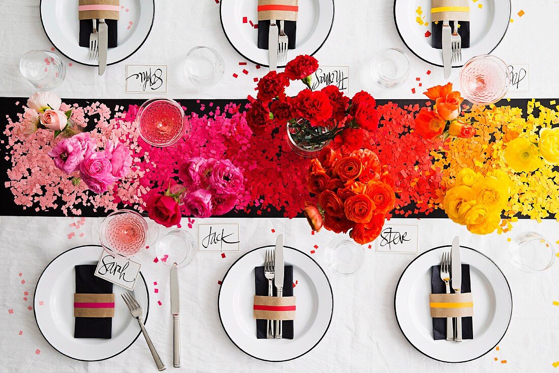 Festlich gedeckter Tisch mit farblich abgestimmtem Konfetti & Blumen