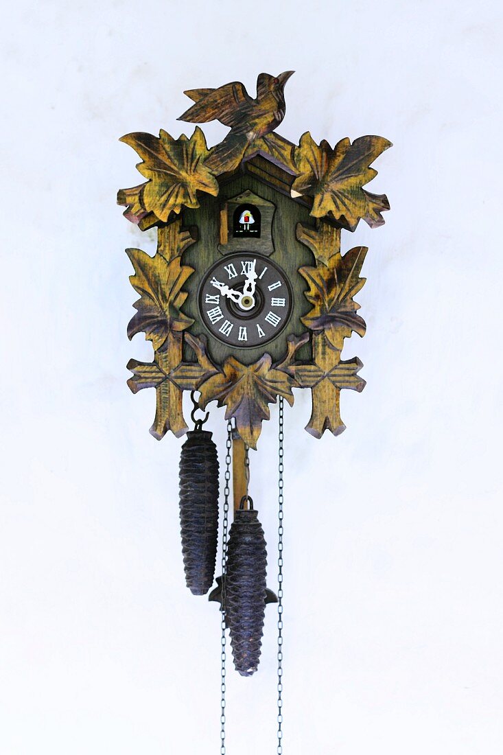 Traditional cuckoo clock with pendulum mounted on wall