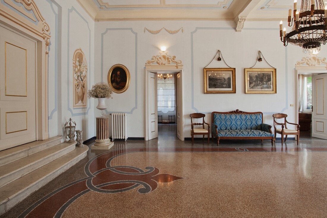 Salon einer ligurischen Villa aus den 20er Jahren mit herrschaftlichem Terrazzoboden und sparsamer, antiker Ausstattung