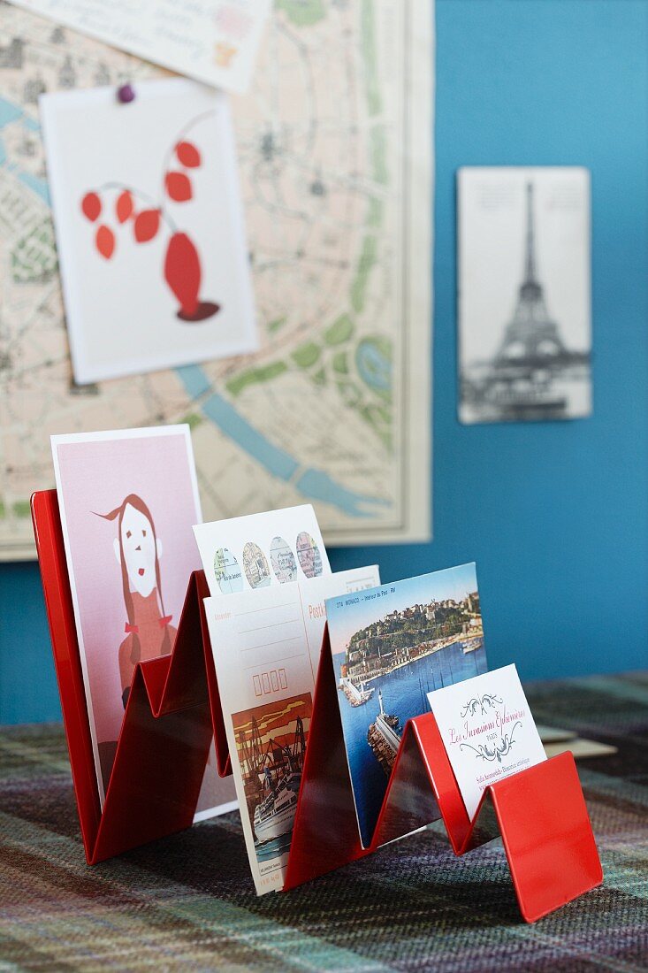 Rot lackierter Postkarten-Aufsteller mit verschiedenen Karten