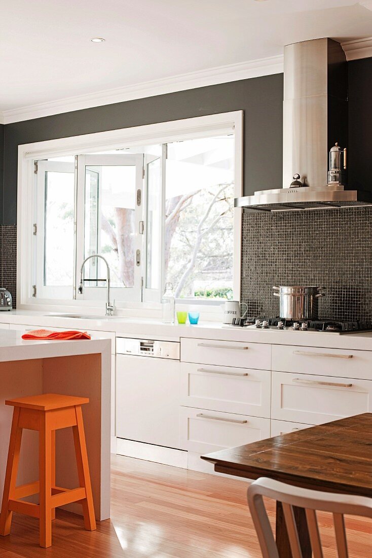 Modern, white fitted kitchen with dark, painted back wall
