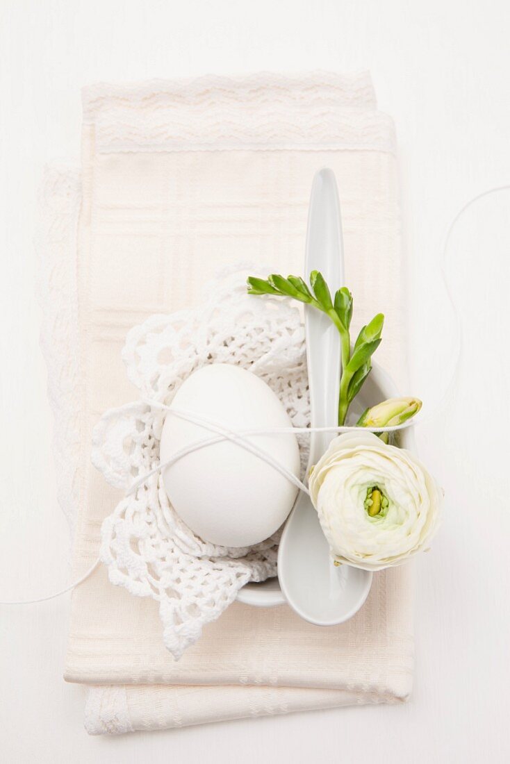 Ei mit Blumenschmuck und Spitzendecke