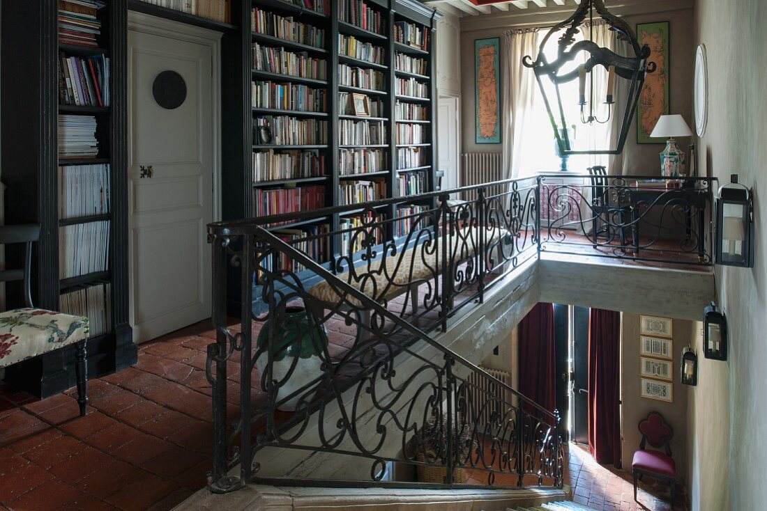 Eingebaute Bücherregale auf Galerie mit Treppenaufgang in traditionellem Landhaus