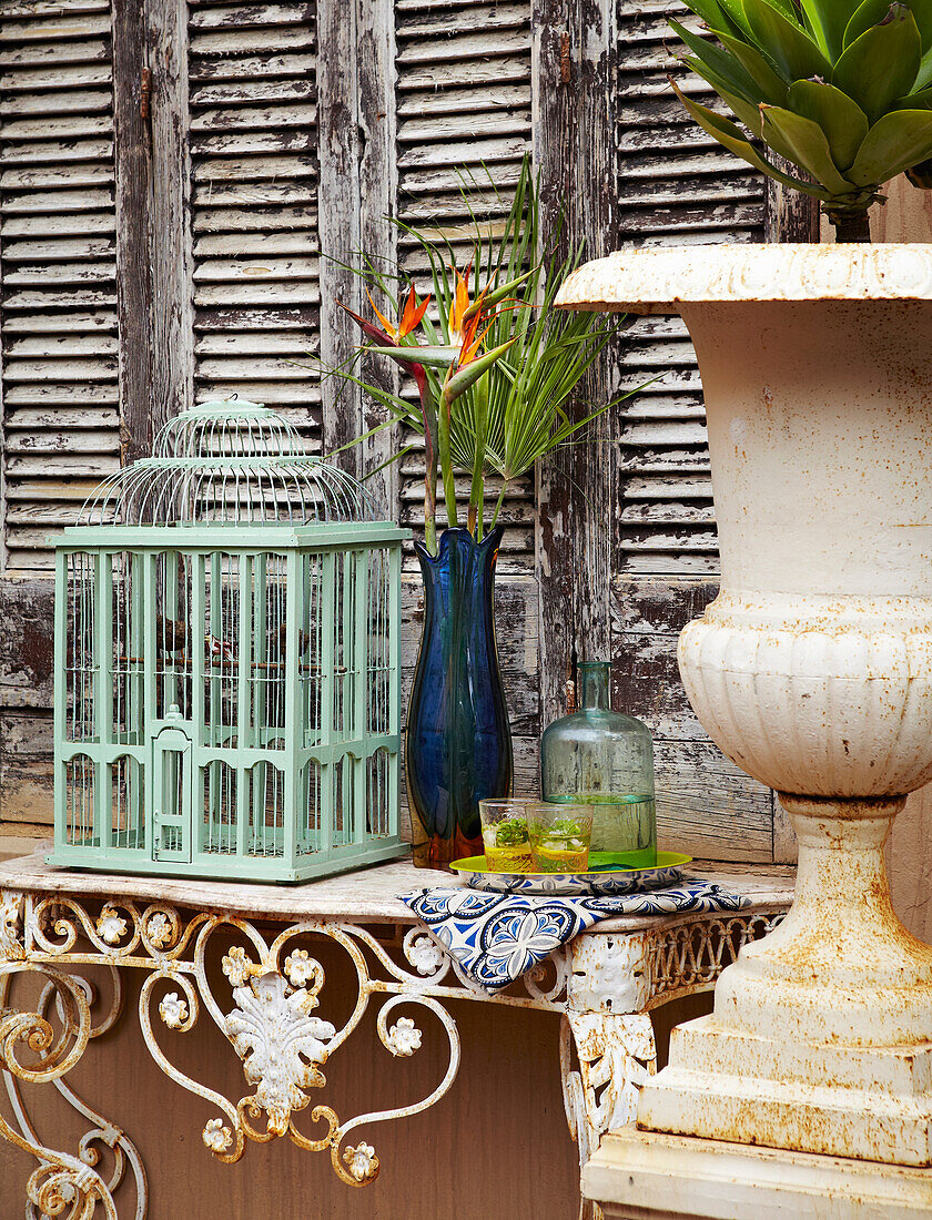 Birdcage and vase on wrought iron and marble console