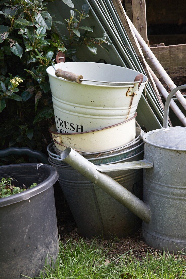 Various buckets and watering cans in garden
