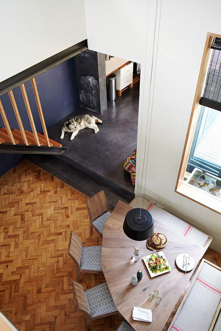 View from above of dining area with wedge-shaped table and walnut chairs