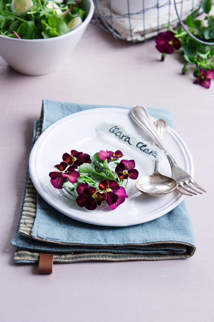 Place setting with wreath of violas and cutlery