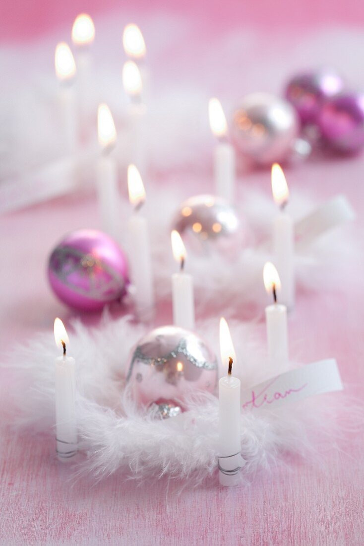 Pink Christmas arrangements of candles, baubles & feathers