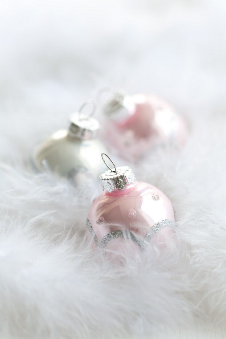 Christmas tree baubles amongst feathers