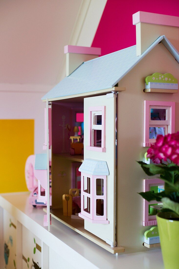 Puppenhaus auf weisser Ablage im Kinderzimmer