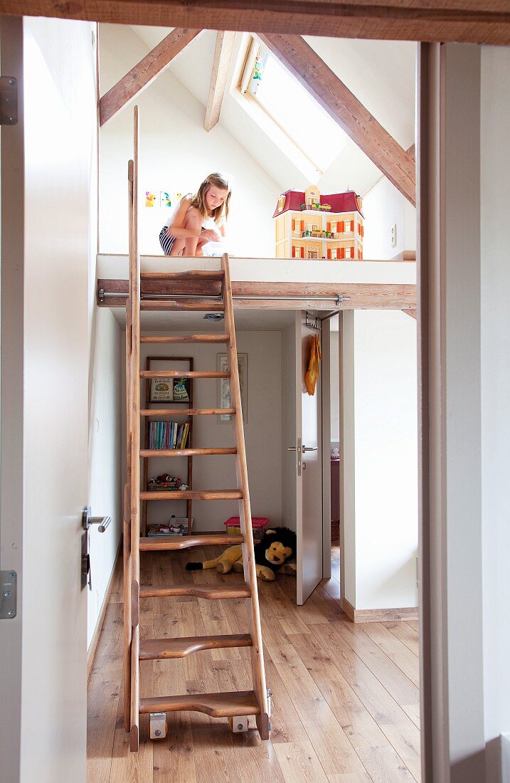 Girl playing on mezzanine level above bedroom accessed via samba stairs