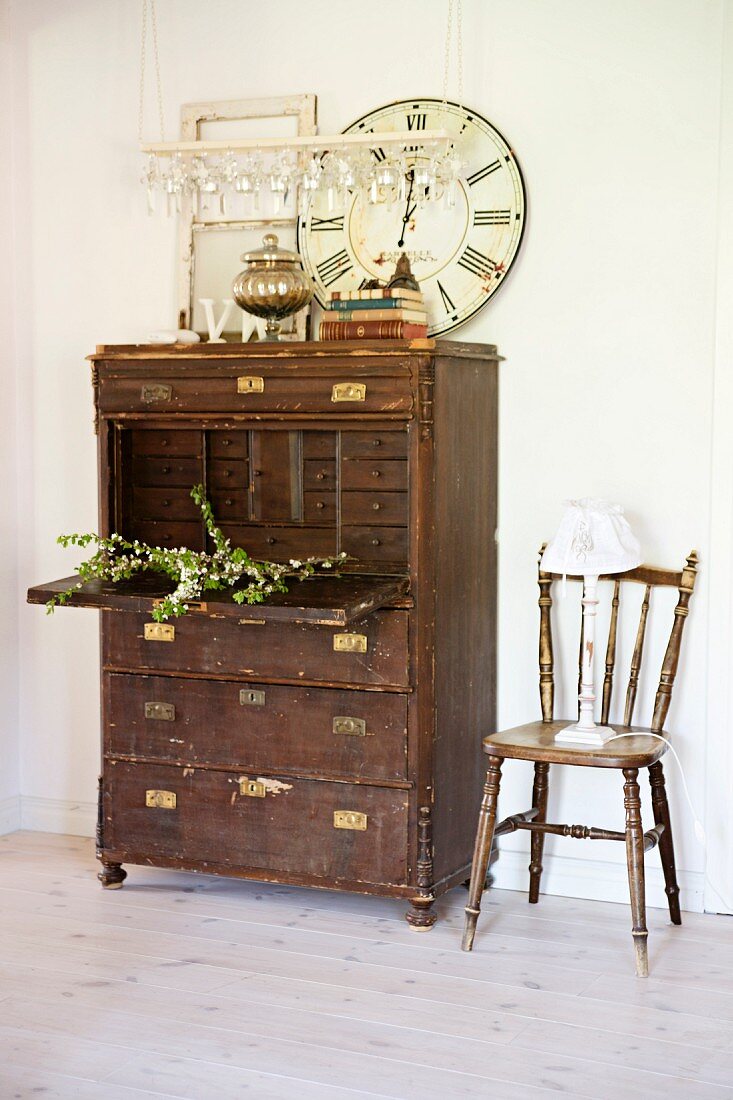 Vintage Sekretär aus dunklem Holz und Stuhl vor Wand in ländlichem Vorraum