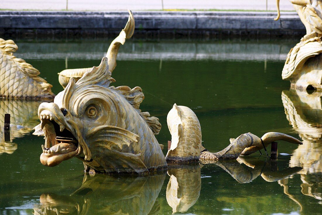 Metal dragon figures in a pond in the Garden of the Palace of Versailles