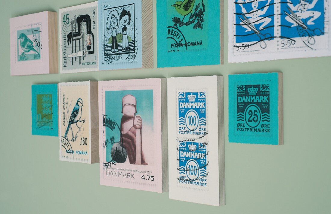 Vergrösserte Briefmarken auf Holztäfeln geklebt als dekorative Bildergalerie an der Wand