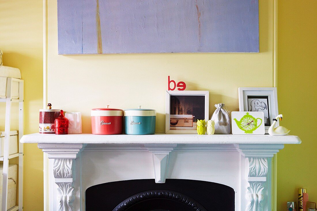 Storage jars on white mantelpiece against wall painted pale yellow