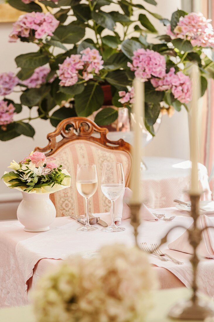 Gedeckter Tisch im stilvollen Restaurant vor Hortensien