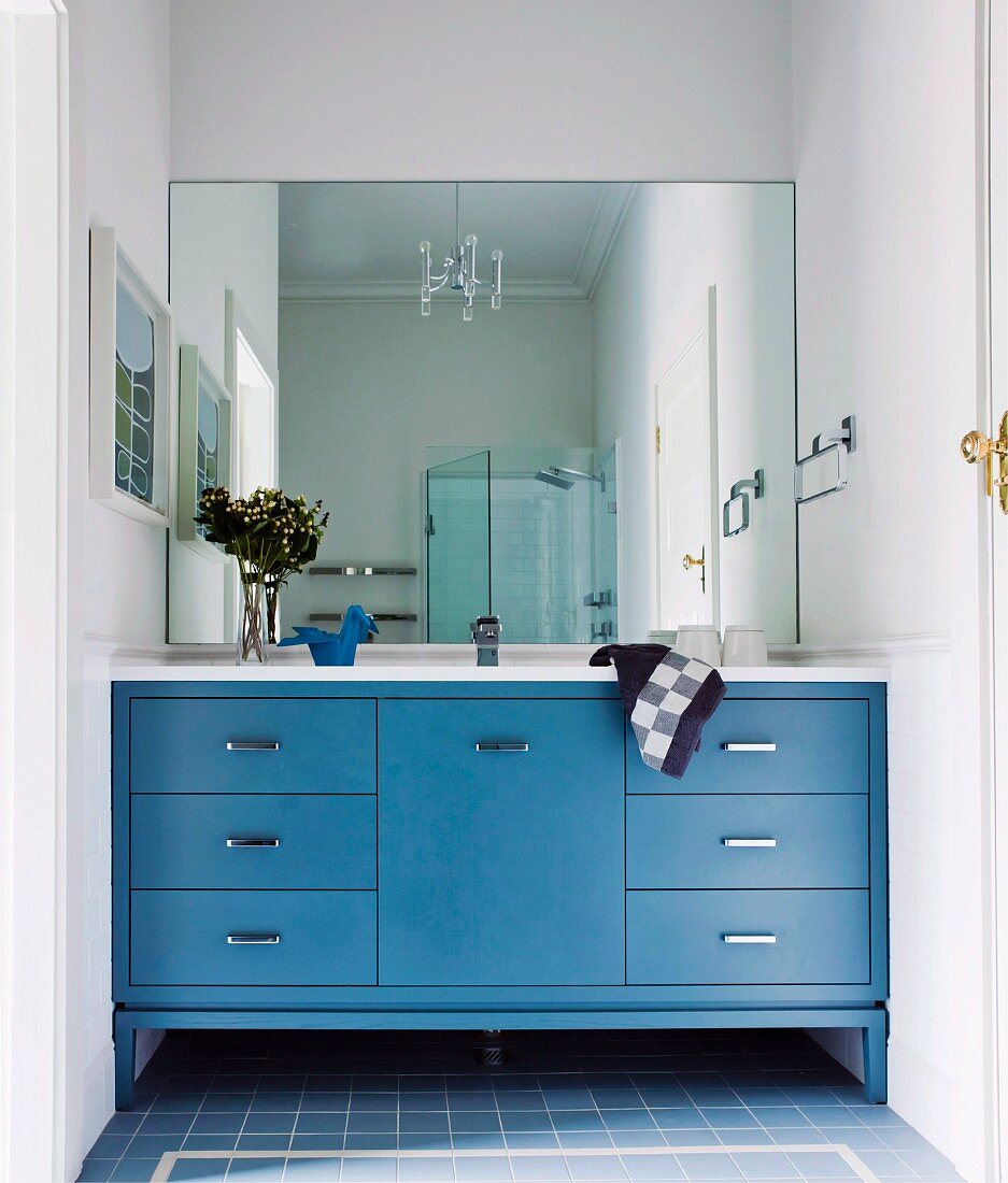 Eingebauter Waschtisch mit blauen Unterschränken, vollflächiger Wandspiegel, in ländlichem Bad