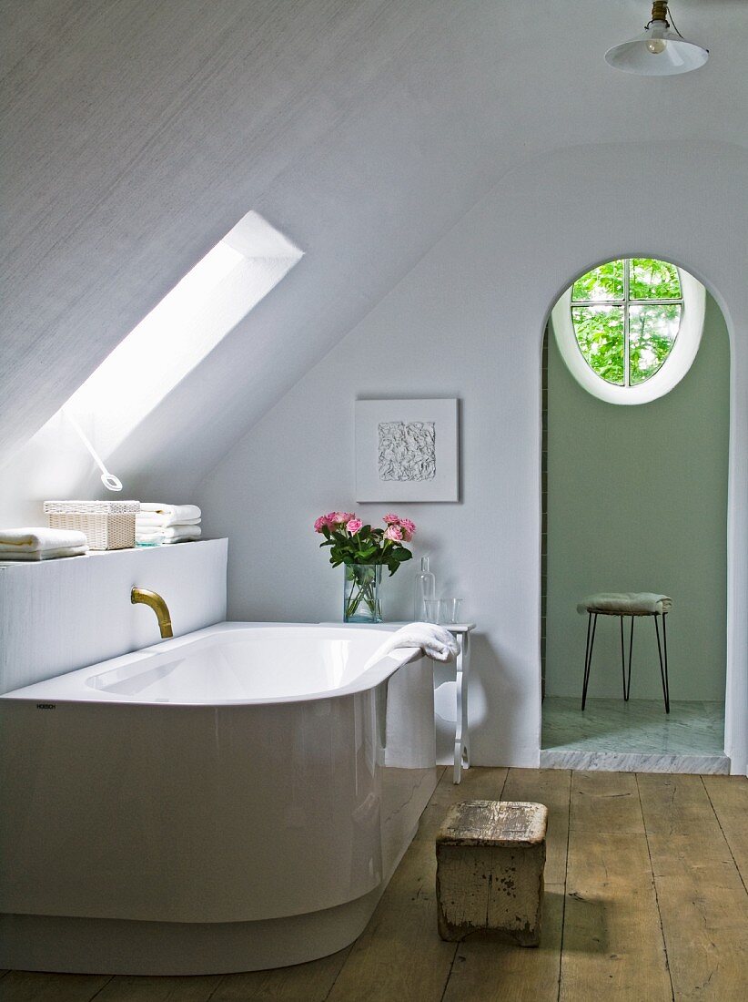 Badewanne von Philippe Starck mit antiker Bronze-Armatur im puristischen Bad