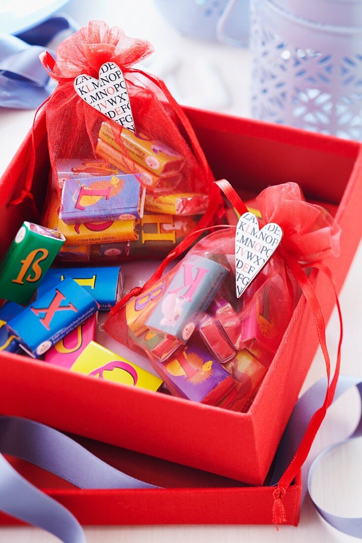 Organzasäckchen mit Buchstaben-Schokoladentäfelchen in roter Geschenkbox