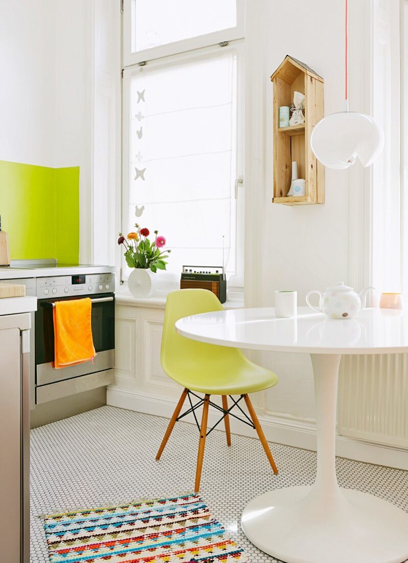 Klassikermöbelmix in Küche - weisser Tulip Table und grüner Schalenstuhl in weisser Küche