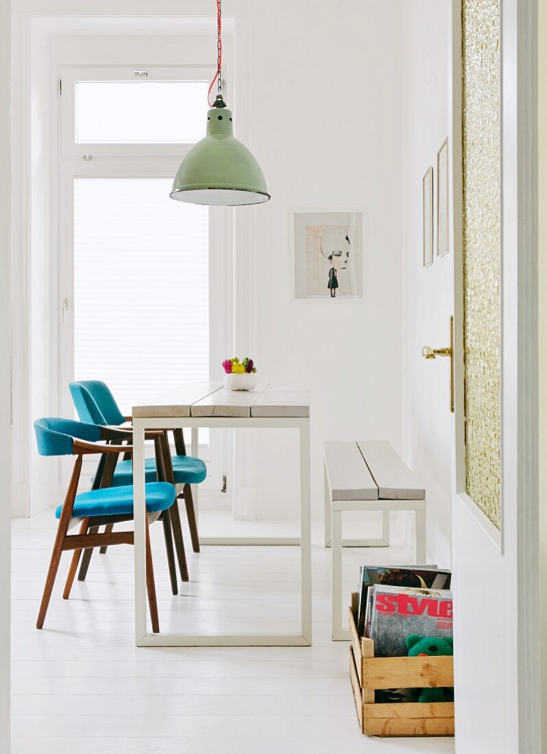 Blick auf selbstgebauten Esstisch mit passender Bank und Stühle mit blauer Polsterung im Fiftiesstil