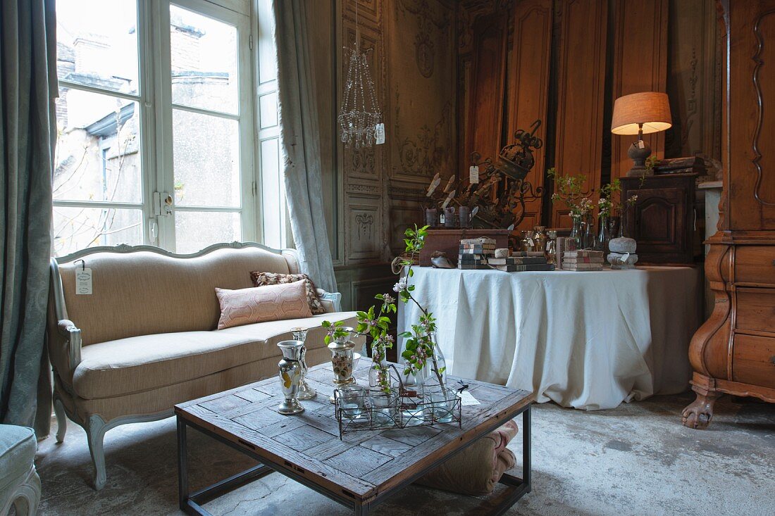 A sales exhibition of living room furniture and antique-style accessories in the parlour of an old French country house