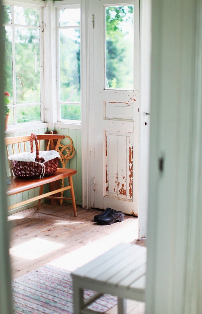 View of bench and chair in porch of old, Swedish wooden house