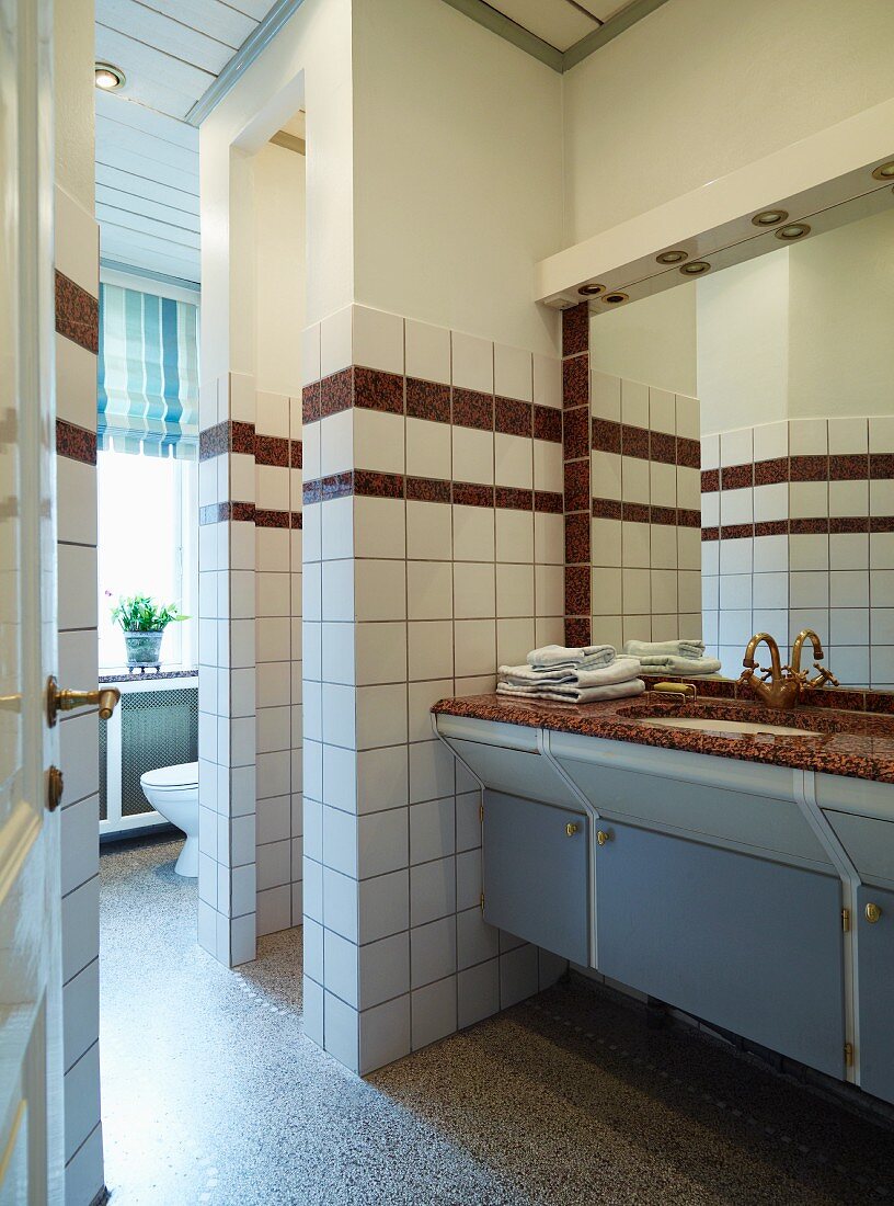Blick durch offene Tür in Badezimmer, Einbau Waschtisch mit Steinplatte, neben gemauertem Duschbereich