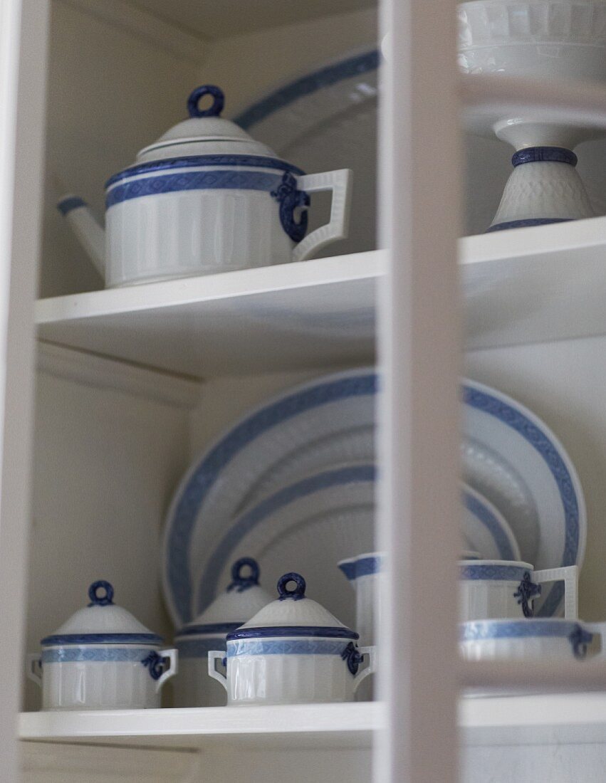 White and blue crockery on white cupboard shelves