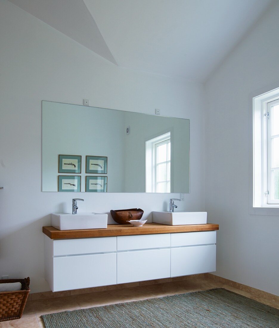 Designer Waschtisch, zwei Aufbaubecken und Holzplatte auf weißem Unterschrank mit Schubladen, an Wand montiert, massgefertigte Spiegel, in minimalistischem Bad