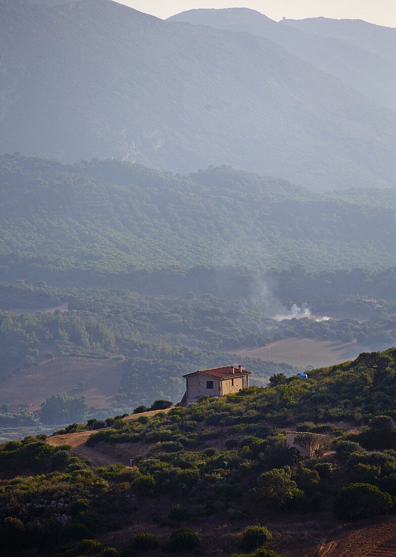 Isolated house on a hillside with view of Mediterranean mountain landscape