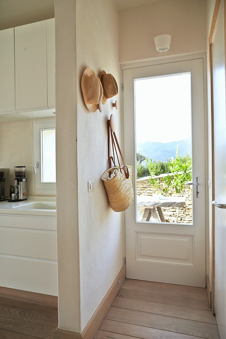 Offener Vorraum mit Blick in Küche und Glasttür vor sonniger Terrasse