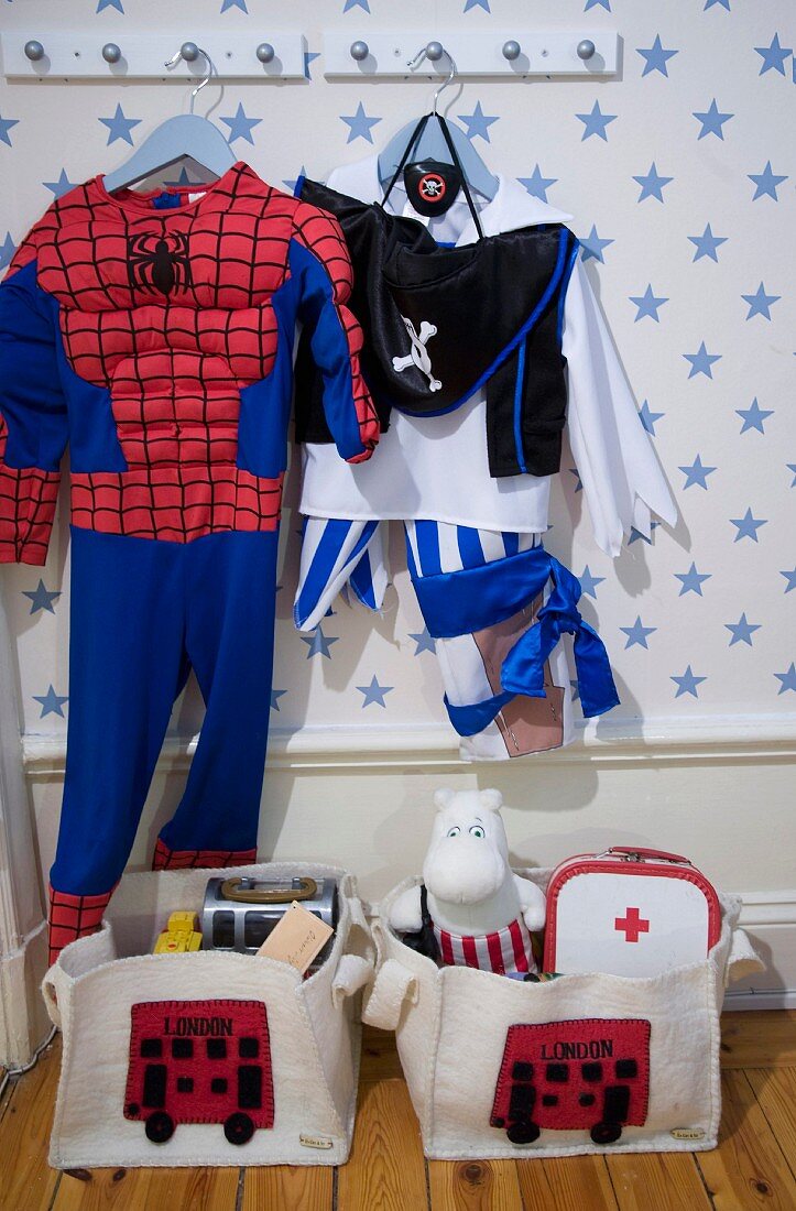 Faschingskostüme, Spiderman, Pirat, auf Wandhakenleiste gehängt im Kinderzimmer