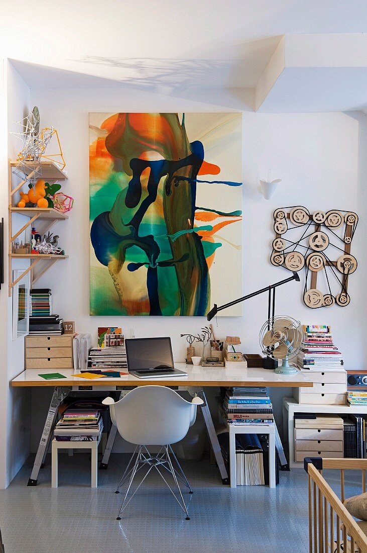 Zeitgenössische Malerei und künstlerische Objekte in Homeoffice mit einfacher Tischplatte auf Leiterbock und klassischem Schalenstuhl