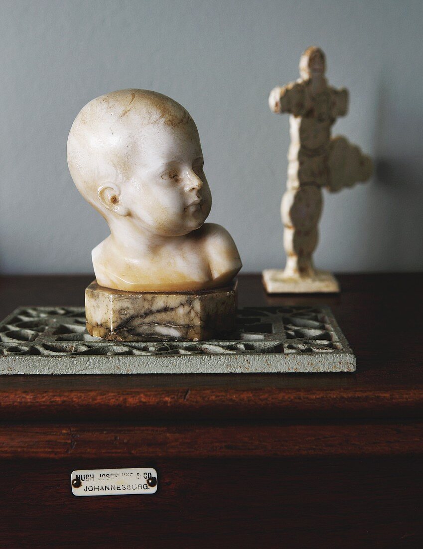 Stone bust of child on trivet