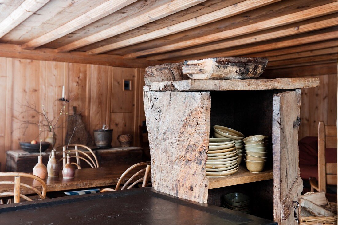 Rustikaler Geschirrschrank aus Holz in einer Holzhütte