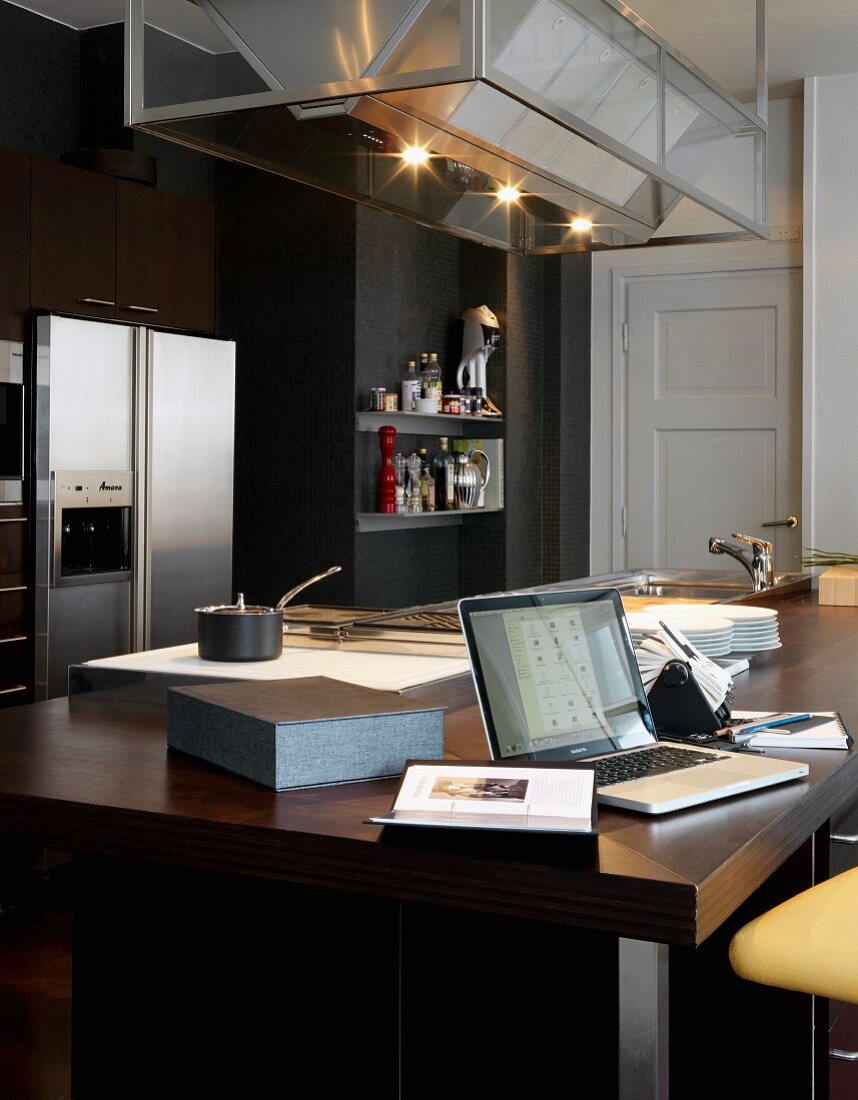 Modern, dark wood kitchen doubles as office space