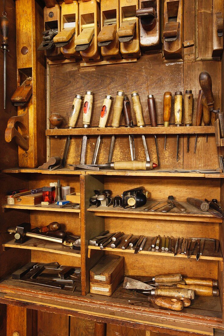 Altes Werkzeugregal mit verschiedenen, traditionellen Schreinerwerkzeugen in allen Größen